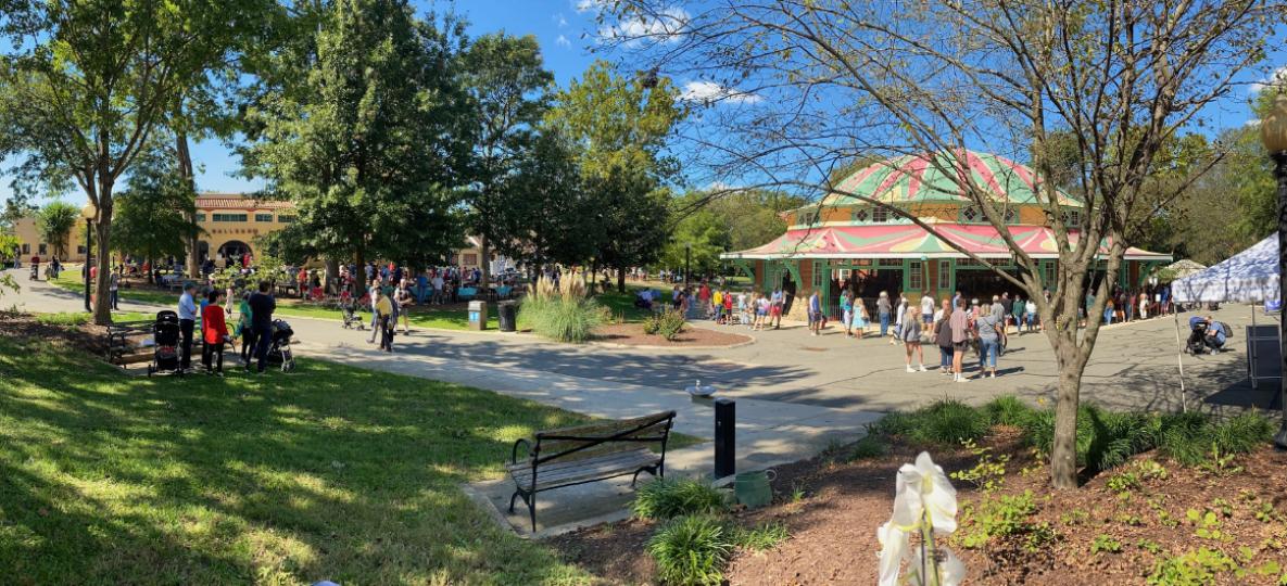 Summer day at Glen Echo Park with visitors, colorful carousel building, and blue sky