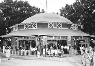 old black and white photo of the carousel with people outside