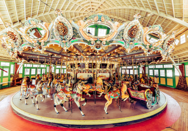 inside of historic carousel, wide shot showing all the animals and the building
