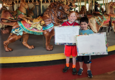 children in the carousel building displaying their artwork