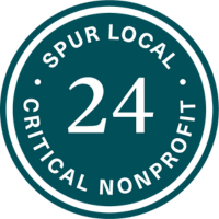 Spur Local round seal with dark teal green background and white lettering