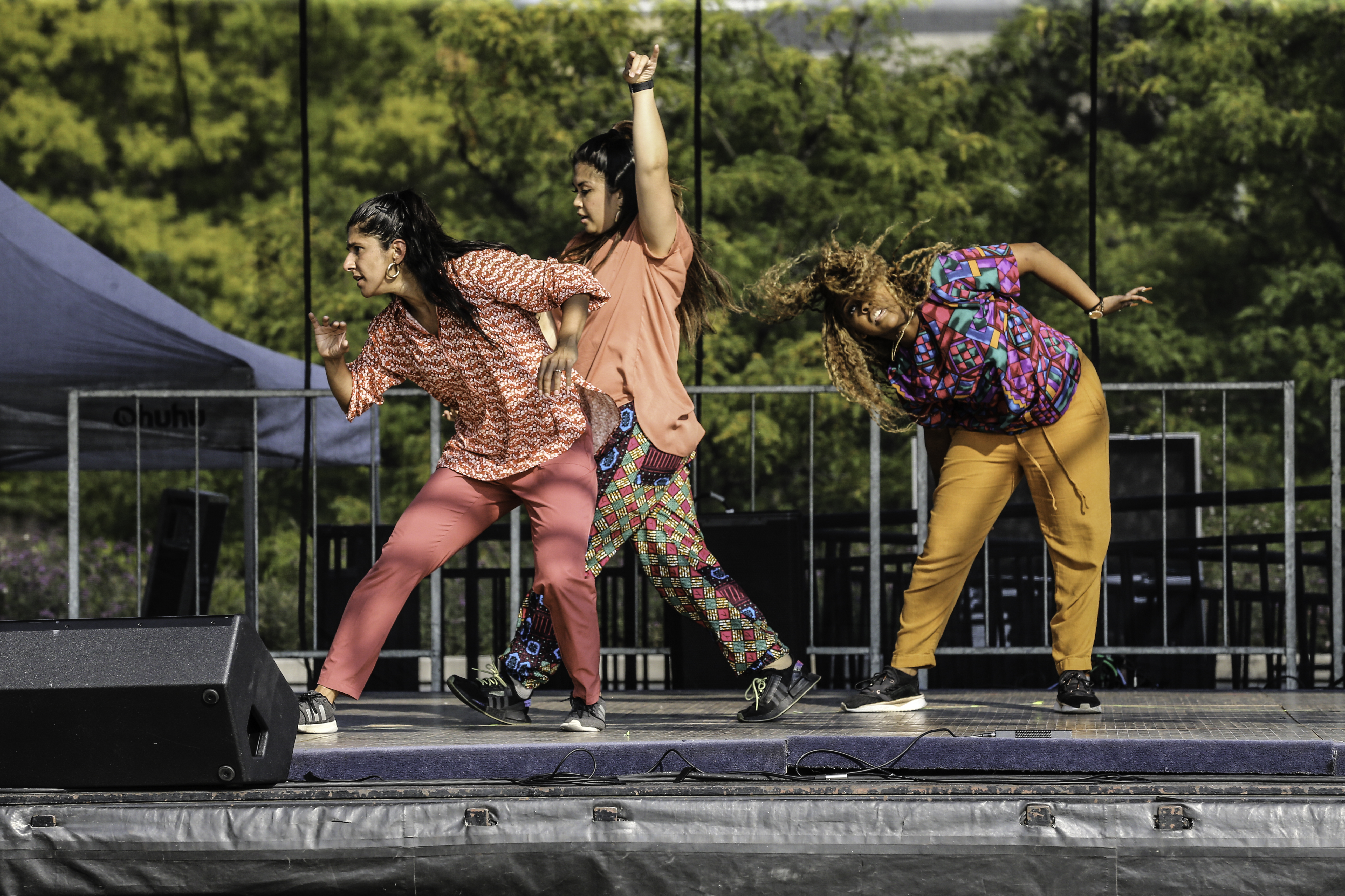 Three female dancers on outdoor stage