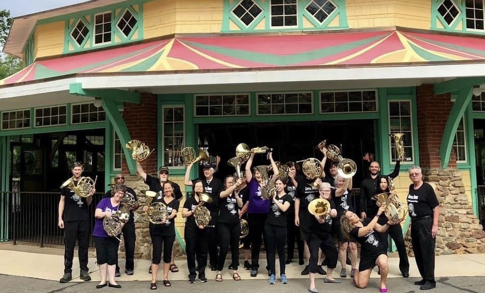 Horn players in front of a carousel