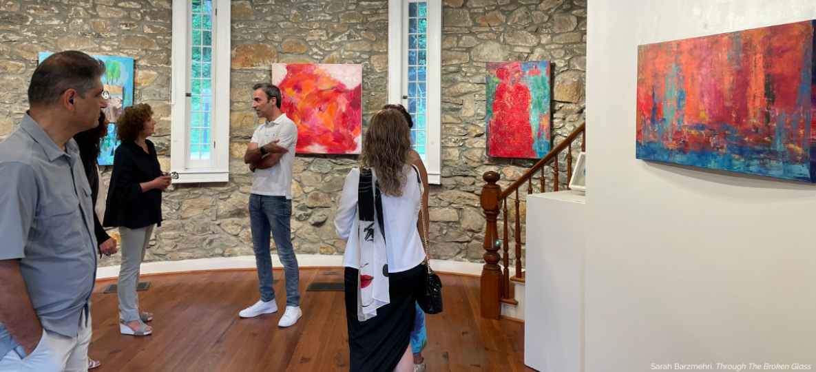 Visitors at artwork displayed on the walls of the Stone Tower Gallery