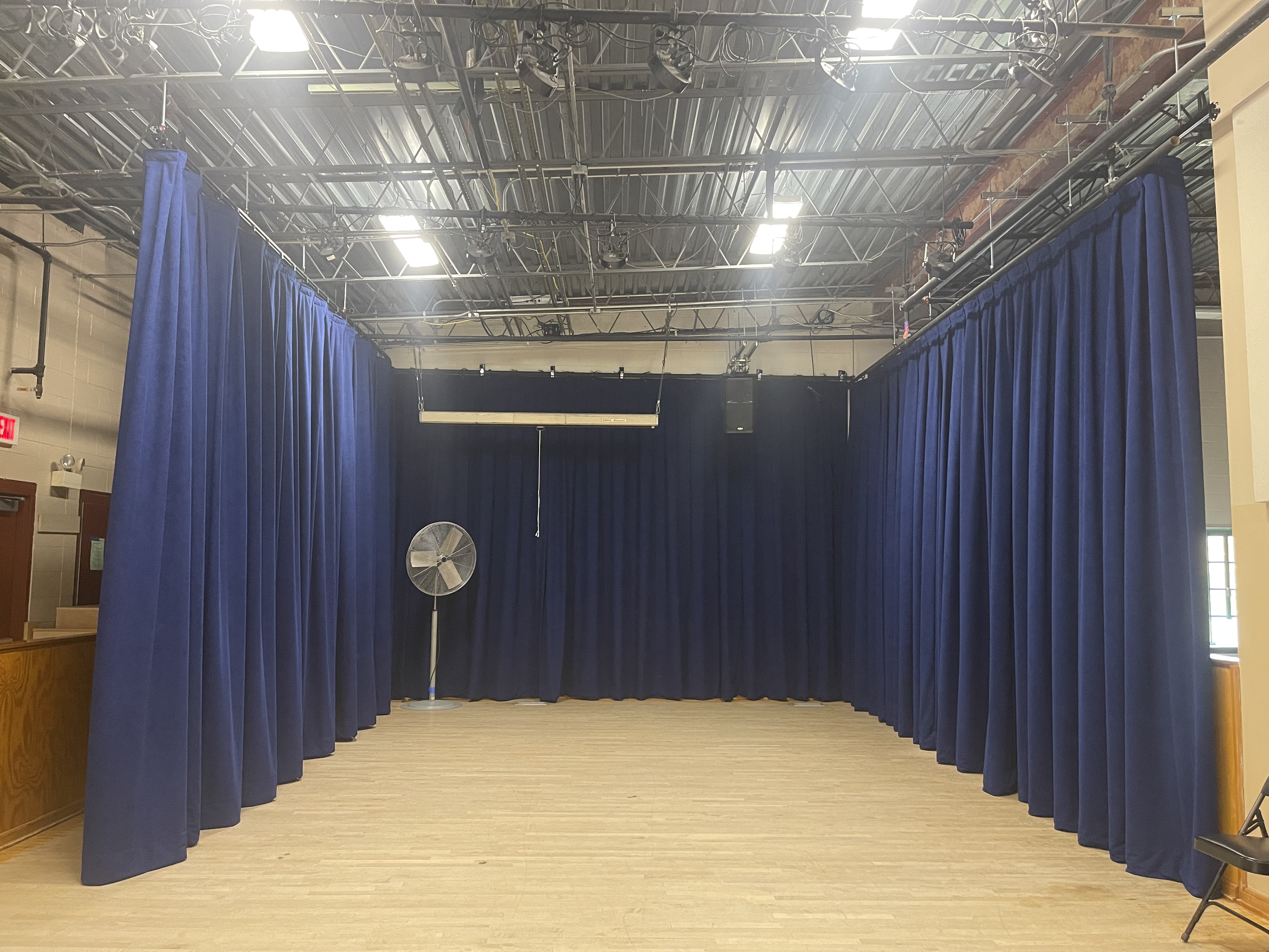 A room with hardwood floors and blue curtains