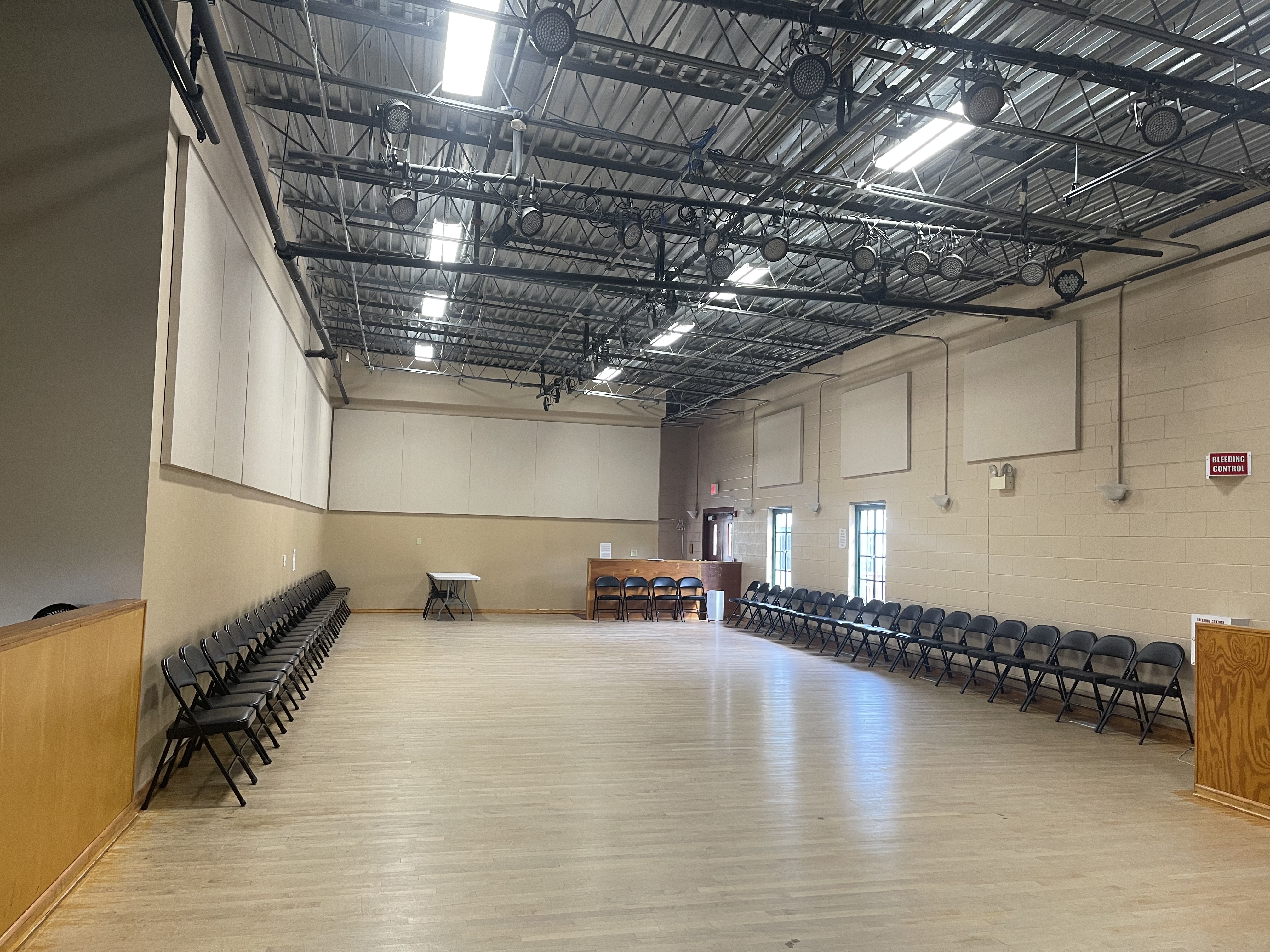 A space with hardwood floors and chairs