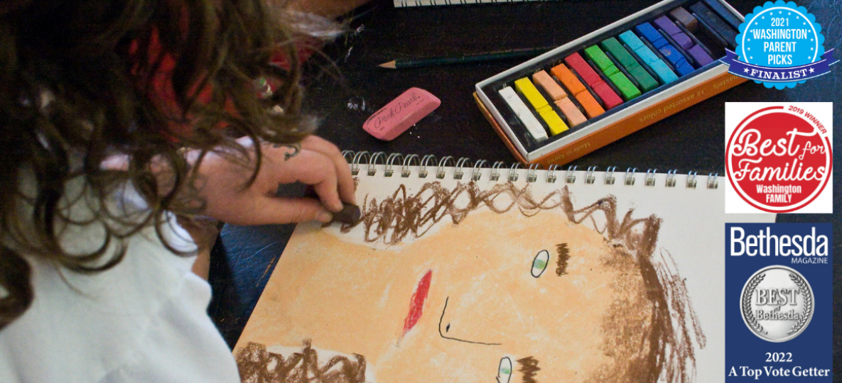 girl drawing a self portrait with colorful crayons