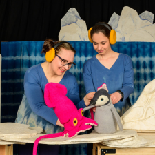 two puppeteers with squid and penguin puppets