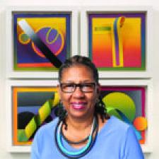 An artist stands in front of their artwork