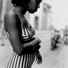 A black and white photo of a woman in a striped outfit