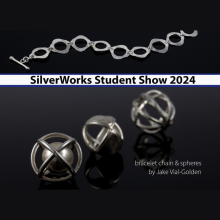 A silver bracelet above three silver spheres on a black background.