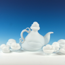 Teapot with clouds against a blue gradient background.