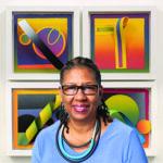 An artist stands in front of their artwork