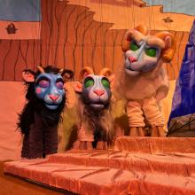 Three goat puppets on a stage