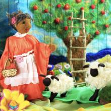 puppet scene with woman, sheep, and apple tree