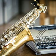 saxophone leaning on typewriter